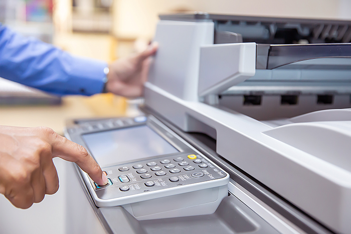 Print operator setting up a document for printing. Using the collate option on the printer will provide a complete document without the need for sorting.